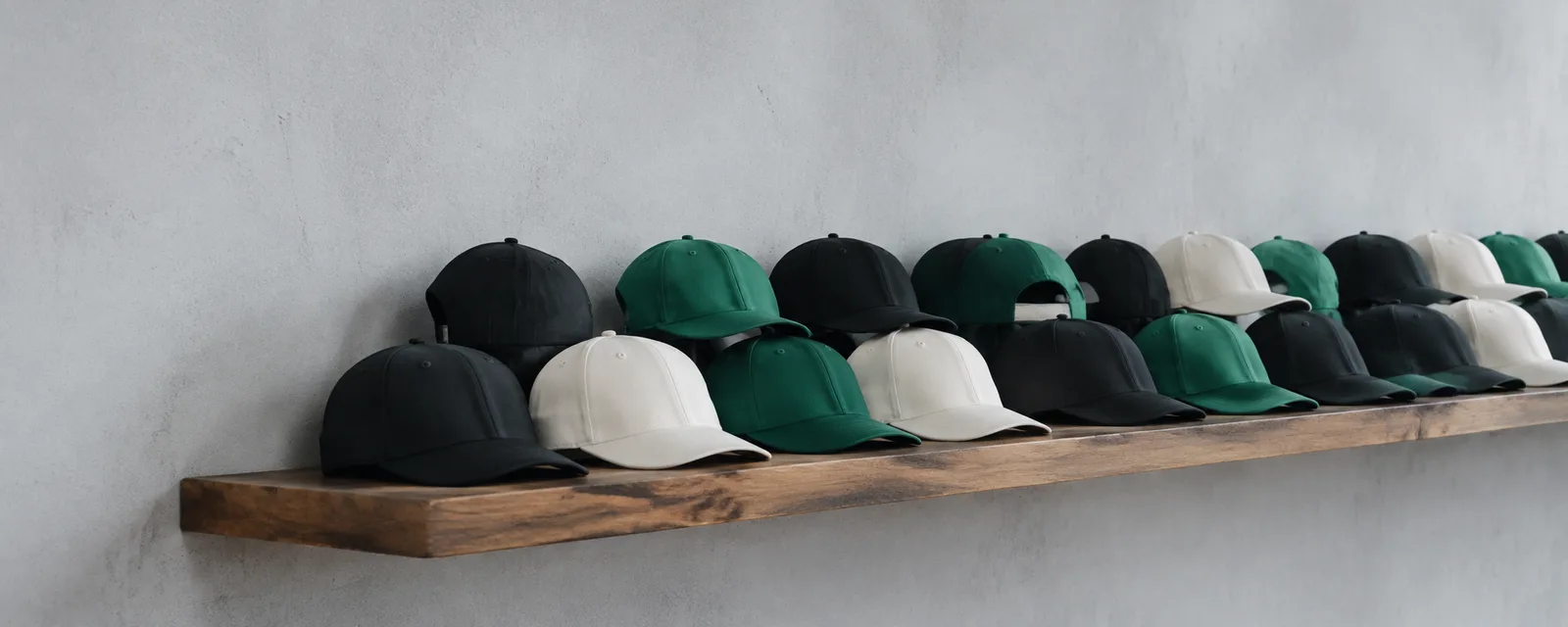 Rows of structured caps in black, white and green on a wooden shelf