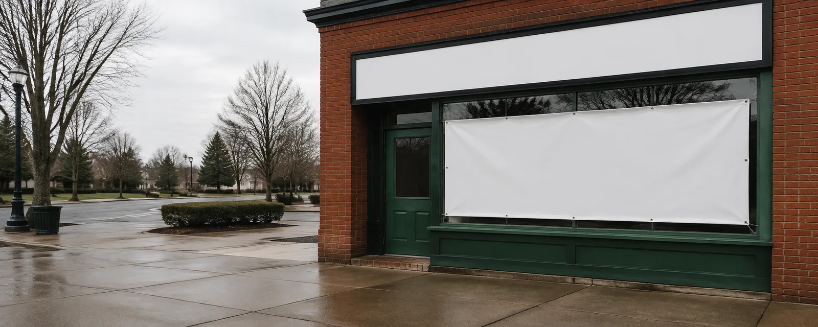 Storefront sign and pavement banner outside a Michigan main street shop