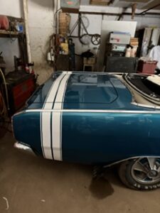 Teal classic car in the shop before graphics