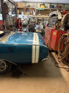 Teal classic car being prepared for lettering