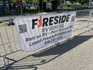 Fireside RV Rental banner mounted on fencing at an event