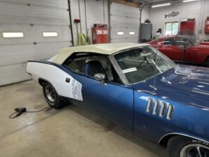Blue Plymouth in the shop with door numbers finished