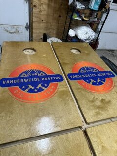 Cornhole boards finished with the Vanderweide Roofing logo