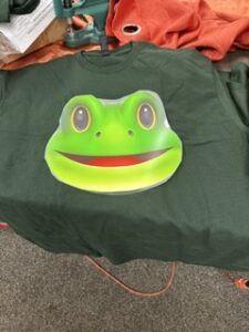 Green tee printed with a large frog graphic