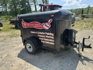 Black utility trailer lettered for a painting and pressure washing company