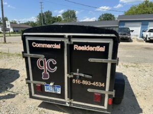 Cargo trailer lettered Commercial and Residential with a phone number