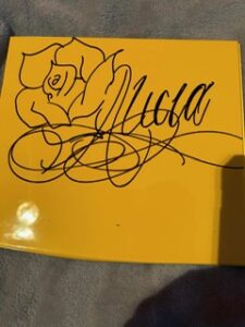 Yellow panel with a hand-drawn rose and script name