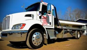 White flatbed tow truck with door graphics