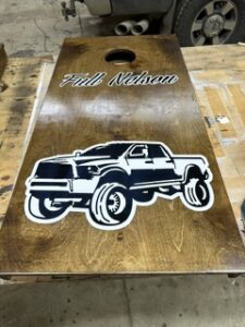Cornhole board with a lifted truck illustration