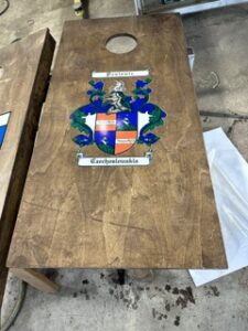 Cornhole board with a blue and gold crest