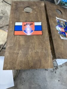 Cornhole board with a blue and orange stripe design