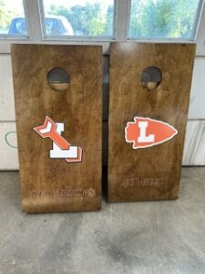 Arrowhead cornhole boards leaning against the shop wall