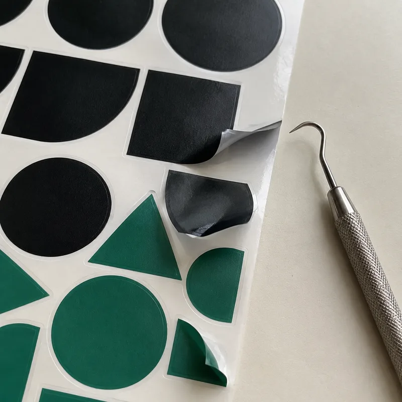 Sheet of die-cut vinyl stickers partially peeled from the backing paper