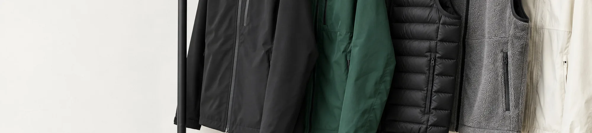 Soft-shell jackets and vests on a black rail